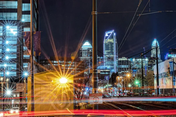 A long exposure photo of a cityscape at night, showcasing vibrant streaks of traffic lights and the illuminated skyline.